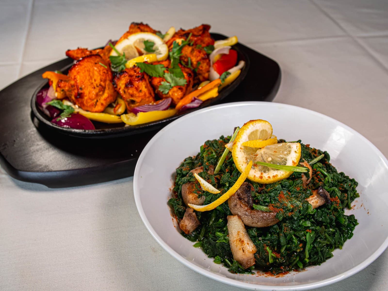 Tandoori chicken and grilled vegetables on a cast iron platter